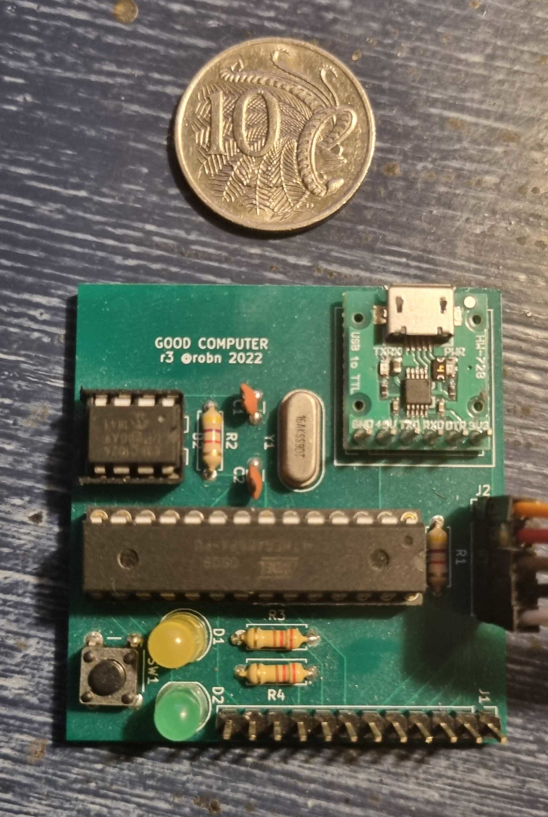 A photograph of a electronic circuit board, with two microchips, two
LEDs, a push button and a number of other components.